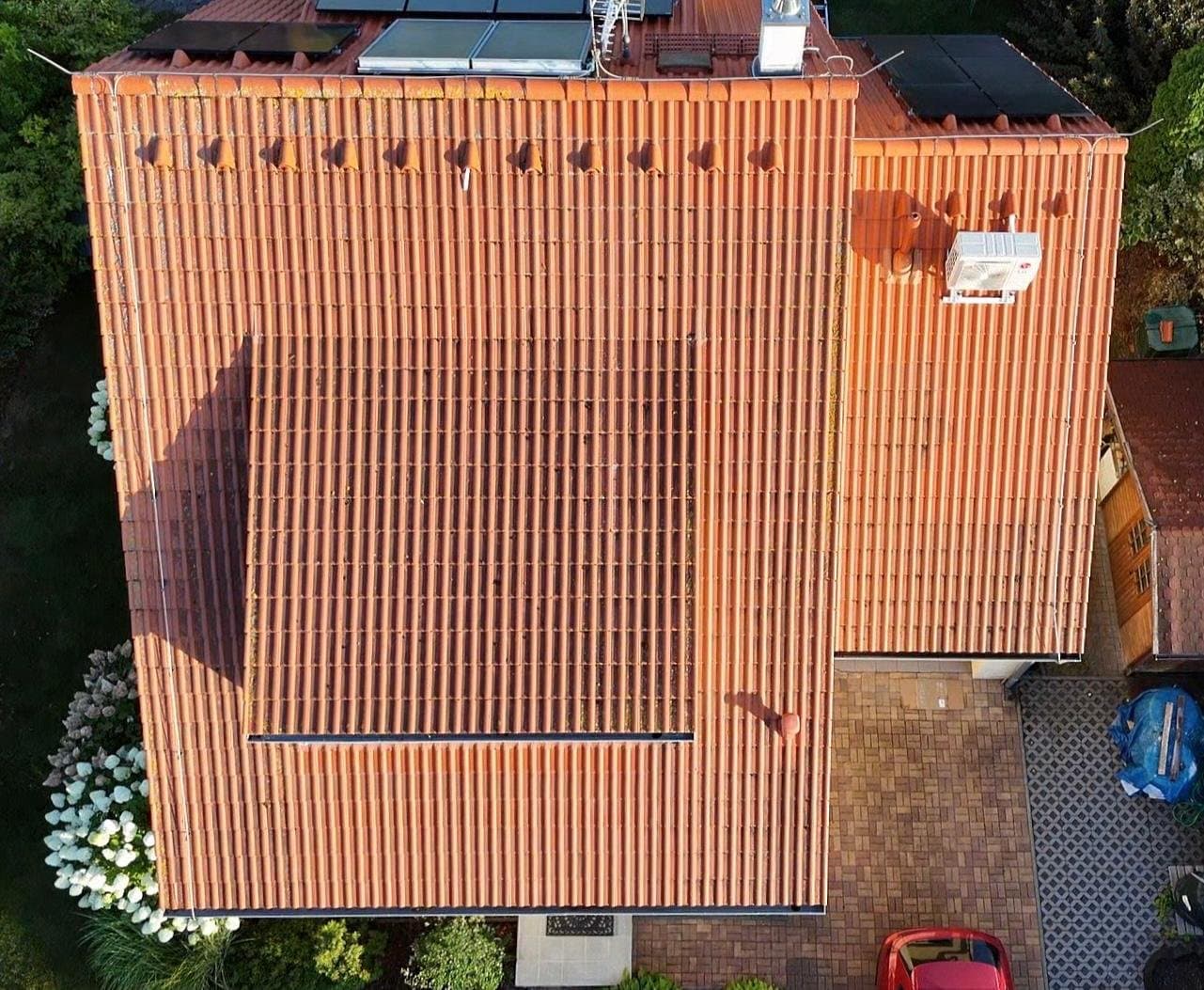 Betonová střecha rodinného domu před vyčištěním, zarostlá mechem a lišejníkem